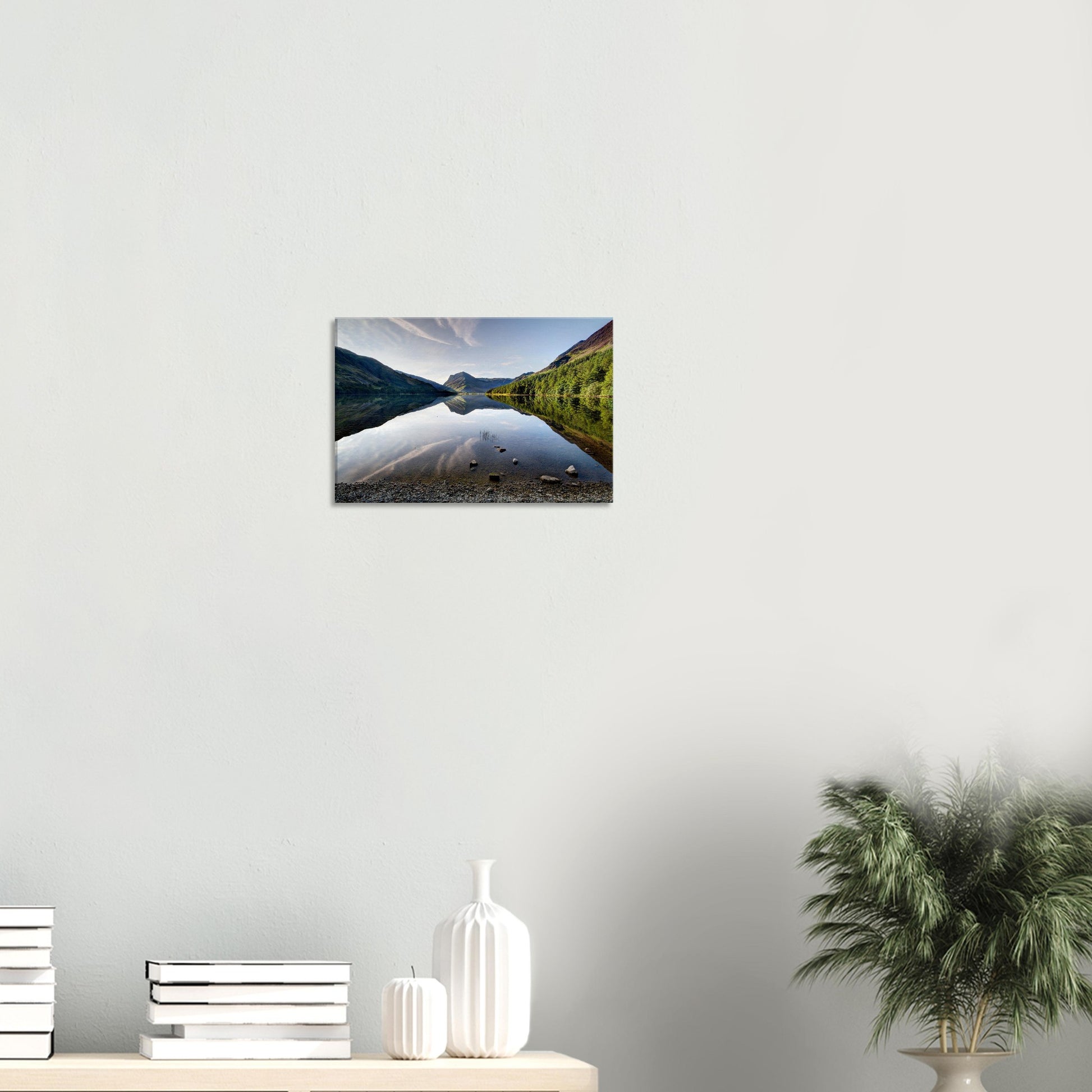 Tranquil canvas artwork of Buttermere Lake featuring mirror-like water, sunlit mountains, and a clear sky reflected in the calm surface.
