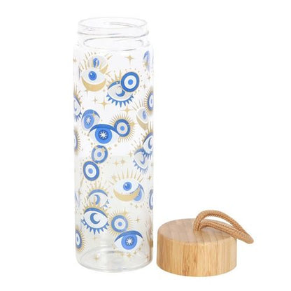 All Seeing Eye Glass Water Bottle with metallic gold details, wood-effect lid, and looped strap for easy carrying.