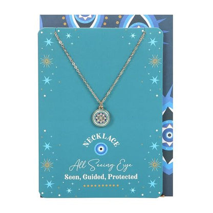 Gold-tone all seeing eye necklace on turquoise card with star accents and matching dark blue envelope.