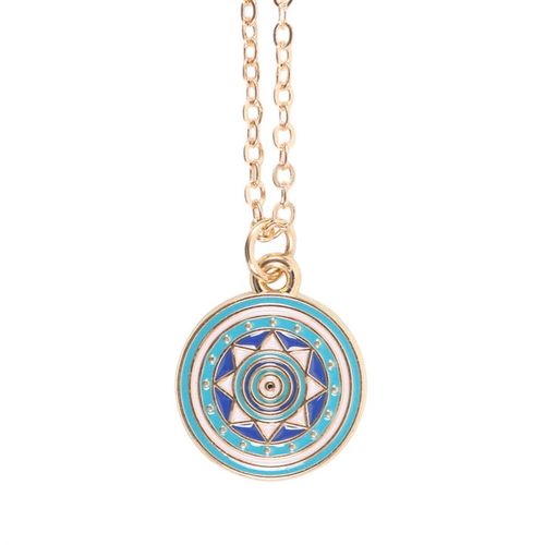 Gold-tone all seeing eye necklace on turquoise card with star accents and matching dark blue envelope.