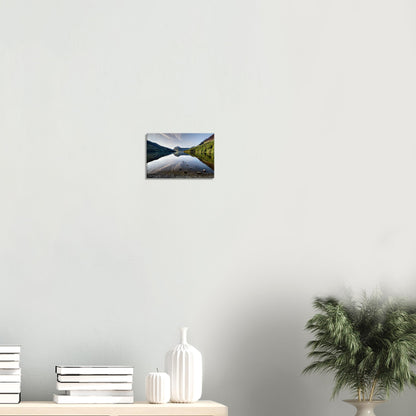 Canvas print of Buttermere Lake’s morning calm, featuring mirrored reflections of the surrounding fells lit by flecks of sunlight.