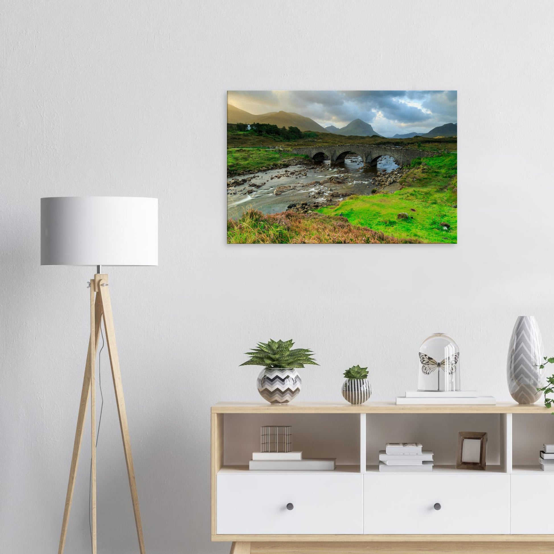 Rustic bridge at Sligachan in a vibrant landscape of riverside stones and distant, misty mountains.