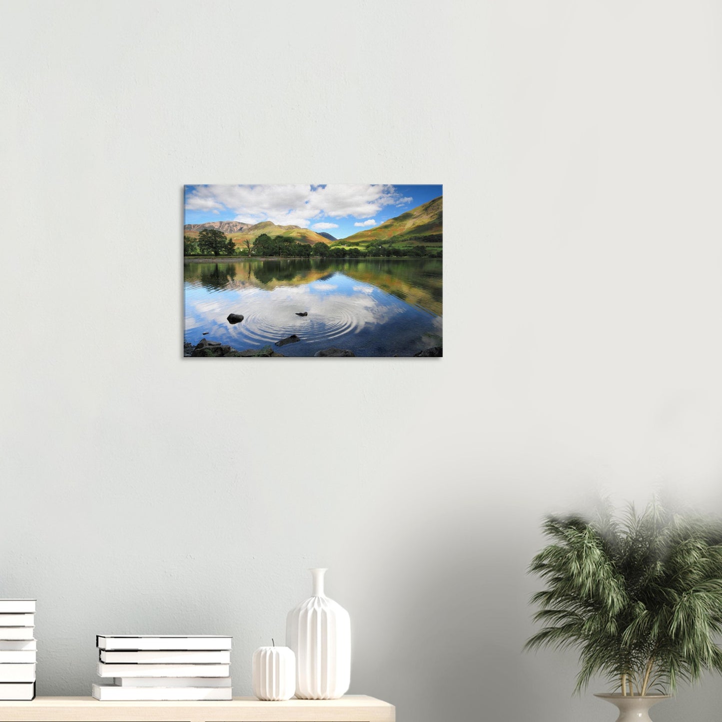 Lake District canvas print of Buttermere featuring disturbed reflections, rolling green slopes, and a ripple expanding across the lake.