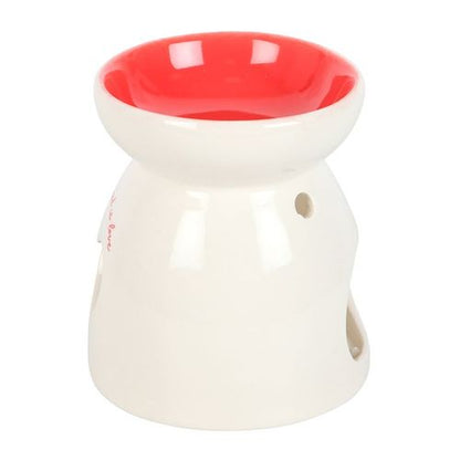 White ceramic oil burner with heart cut-out and "All you need is love" text, perfect for romantic and heartfelt gifting.