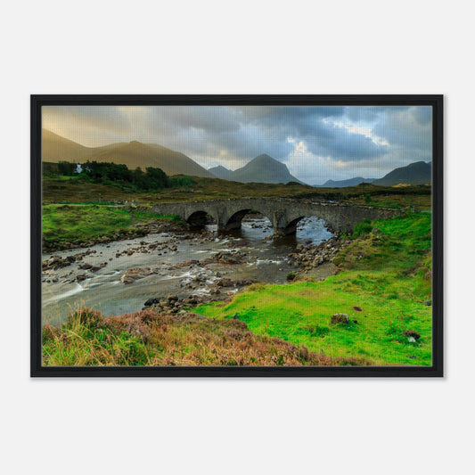 Ancient stone bridge crossing river with Cuillin mountains behind