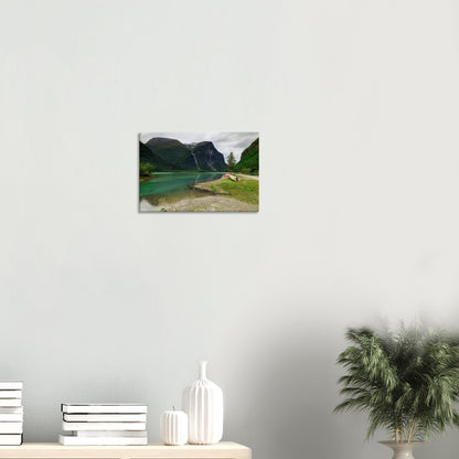 Serene lakeside scene with bright green foliage, boats moored at the shore, and a majestic waterfall backdrop