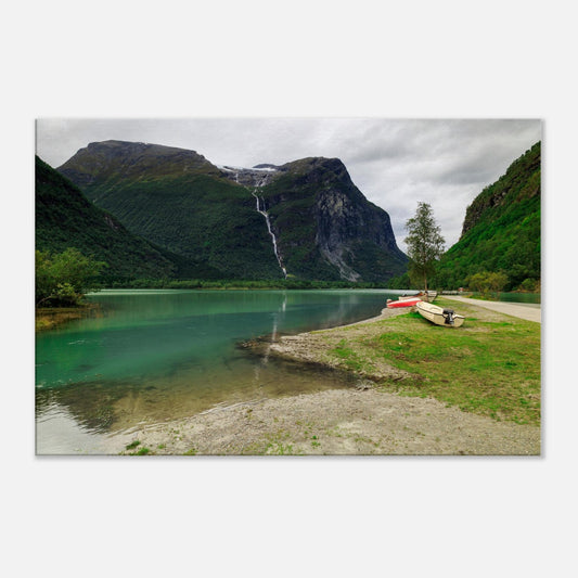 Majestic mountain scene with vibrant green countryside and a powerful waterfall flowing into a tranquil lake