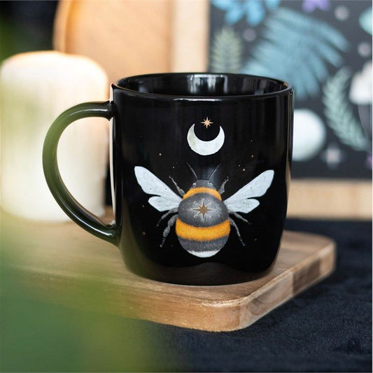 Black ceramic mug with dark forest bee design, crescent moon, and stars. 340ml capacity.