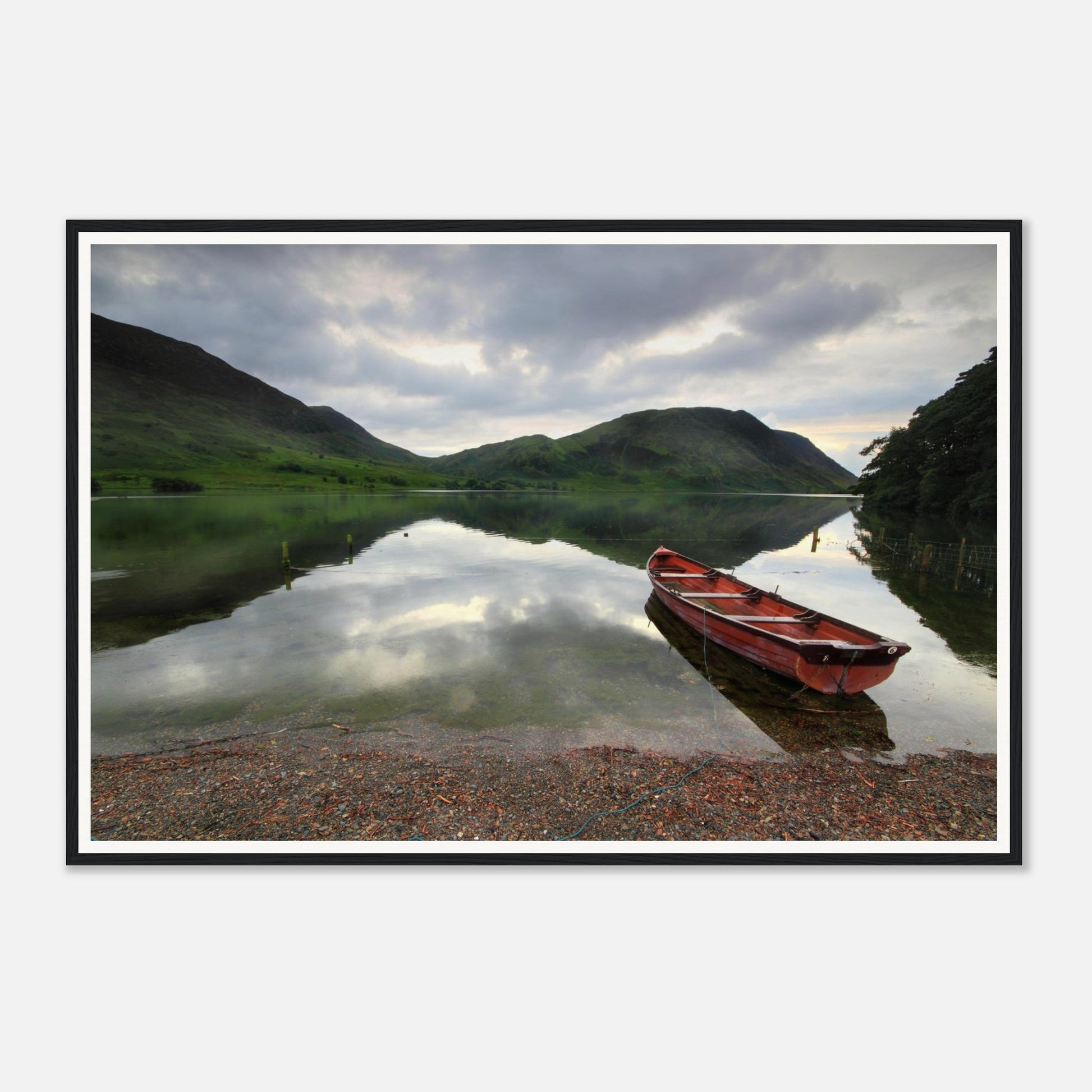 Solitary red boat on the shore of Crummock Water in Cumbria