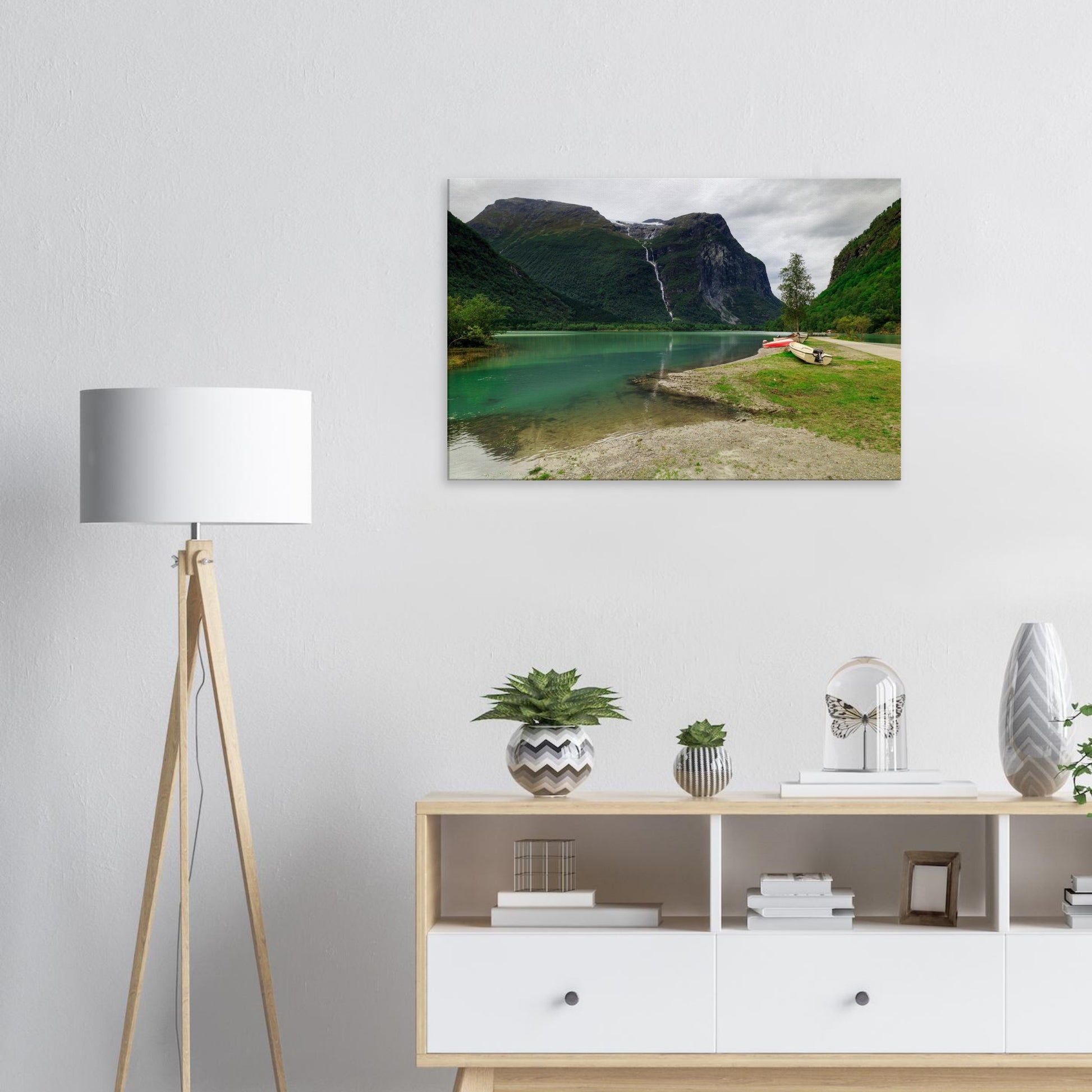 Inviting lakeside view with boats anchored near a waterfall’s base, set against a dramatic mountainous skyline