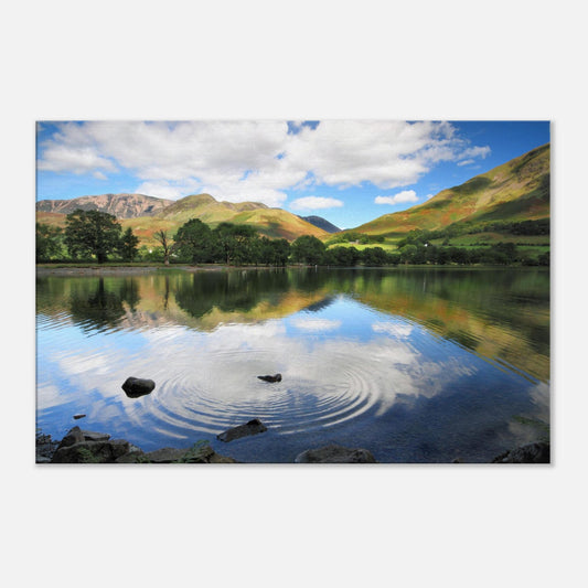 Tranquil Buttermere Lake canvas print featuring disturbed reflections from a single ripple and lush Cumbrian hills in soft light.