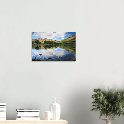 Canvas print capturing Buttermere Lake’s serene waters, with ripples expanding from a single stone across mirror-like reflections.