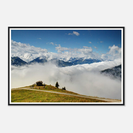 Solitary hut on verdant hilltop surrounded by clouds in Austria