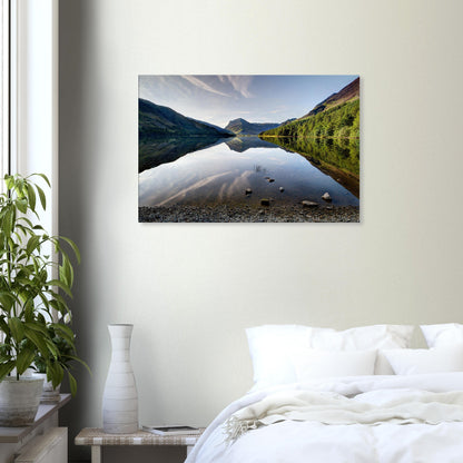 Canvas print capturing the reflective calm of Buttermere Lake with mirrored fells and a touch of morning sunlight on jagged peaks.