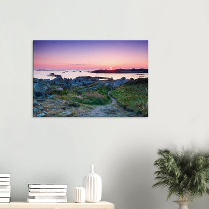 Canvas print of Guernsey’s Lihou Island with a tranquil footpath, wildflowers, and tide pools lit by golden sunset rays.