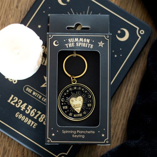 Gold-tone metal talking board planchette keyring that spins, presented in a matching box.