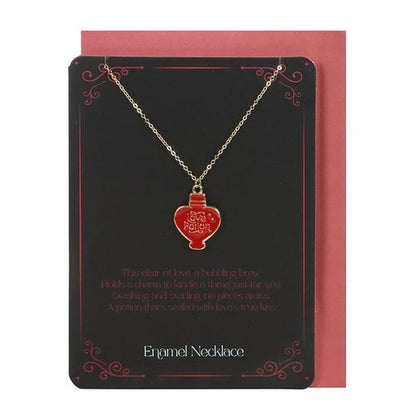 Gold-tone necklace with an enamel love potion charm, presented on a matching greeting card with an envelope.