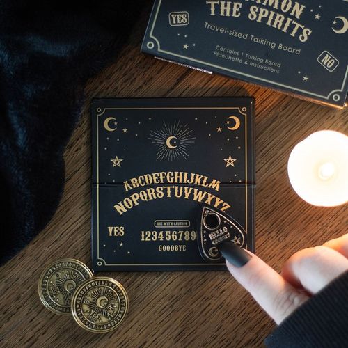 Travel-sized black and gold talking board with mini spirit board and planchette, designed for light-hearted entertainment.