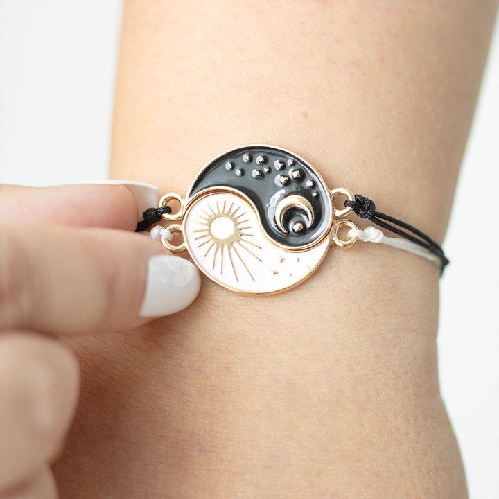 Pair of Yin and Yang bracelets with sun and moon charms symbolising balance.